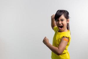 COVID 19 Vaccines for Kids concept. Studio a portrait of an adorable Asian girl after getting his first dose of vaccine. Immune, Safe, Available, Back to school. photo