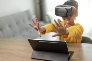 linda chica usando gafas de realidad virtual en casa, experimento de educación remota, futuro hoy, nueva educación en línea, estilo de vida interior foto