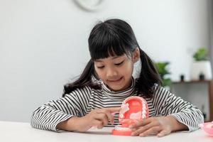 un niño pequeño juega con mandíbulas artificiales. odontologia infantil. foto