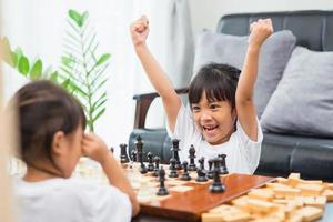 Kids playing chess - one of them just captured a pawn and celebrates photo