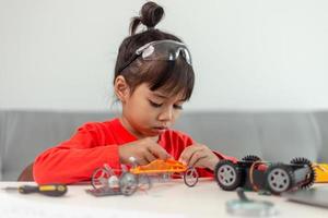 Asia students learn at home in coding robot cars and electronic board cables in STEM, STEAM, mathematics engineering science technology computer code in robotics for kids concept. photo