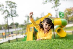 Asian little girl enjoys playing in a children playground, Outdoor portrait photo