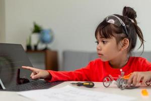 Asia students learn at home in coding robot cars and electronic board cables in STEM, STEAM, mathematics engineering science technology computer code in robotics for kids concept. photo