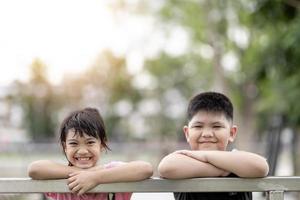 dos niños asiáticos, niño y niña, felices y sonrientes en el parque foto