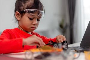 Asia students learn at home in coding robot cars and electronic board cables in STEM, STEAM, mathematics engineering science technology computer code in robotics for kids concept. photo