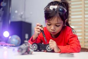 los estudiantes de asia aprenden en casa a codificar autos robot y cables de tableros electrónicos en tallo, vapor, ingeniería matemática, ciencia, tecnología, código de computadora en robótica para el concepto de niños. foto