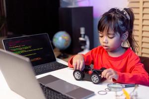 los estudiantes de asia aprenden en casa a codificar autos robot y cables de tableros electrónicos en tallo, vapor, ingeniería matemática, ciencia, tecnología, código de computadora en robótica para el concepto de niños. foto