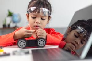 Asia students learn at home in coding robot cars and electronic board cables in STEM, STEAM, mathematics engineering science technology computer code in robotics for kids concept. photo
