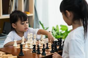 dos lindos niños jugando al ajedrez en casa foto