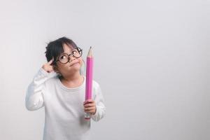 Excited young girl kid holding up big pencils in her hands.Back to school. photo