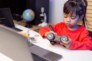 Asia students learn at home in coding robot cars and electronic board cables in STEM, STEAM, mathematics engineering science technology computer code in robotics for kids concept. photo