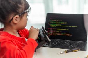 los estudiantes de asia aprenden en casa a codificar autos robot y cables de tableros electrónicos en tallo, vapor, ingeniería matemática, ciencia, tecnología, código de computadora en robótica para el concepto de niños. foto