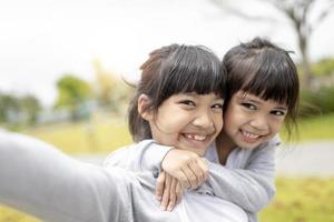 Happy Asian child takes a selfie in the park. photo