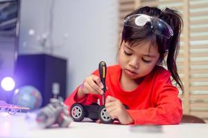 Asia students learn at home in coding robot cars and electronic board cables in STEM, STEAM, mathematics engineering science technology computer code in robotics for kids concept. photo