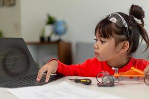 Asia students learn at home in coding robot cars and electronic board cables in STEM, STEAM, mathematics engineering science technology computer code in robotics for kids concept. photo