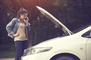 Young woman with broken car calling for help.Vintage color photo