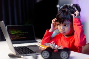 los estudiantes de asia aprenden en casa a codificar autos robot y cables de tableros electrónicos en tallo, vapor, ingeniería matemática, ciencia, tecnología, código de computadora en robótica para el concepto de niños. foto