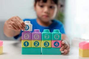 Little child girl playing colorful blocks photo