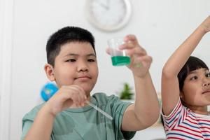 Asian Children enthusiastically watch chemistry experiments. photo