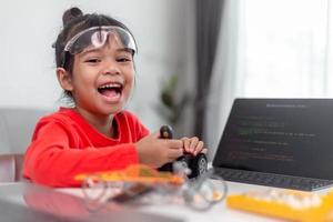 los estudiantes de asia aprenden en casa a codificar autos robot y cables de tableros electrónicos en tallo, vapor, ingeniería matemática, ciencia, tecnología, código de computadora en robótica para el concepto de niños. foto