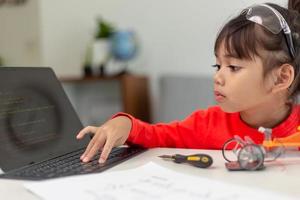 Asia students learn at home in coding robot cars and electronic board cables in STEM, STEAM, mathematics engineering science technology computer code in robotics for kids concept. photo