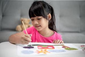 Girl Painting Picture On Table At Home photo