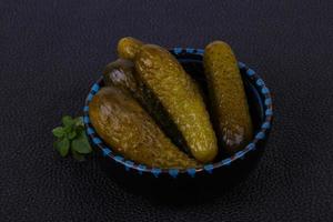 Pickled cucumbers heap in the bowl photo