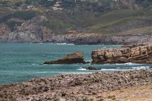 The waves fighting about deserted rocky coast of Atlantic ocean, Portugal photo