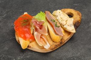 Tapas - bruschetta with prosciutto, salmon, duck and gorgonzola photo