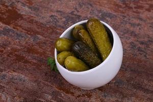 Pickled cucumbers heap in the bowl photo