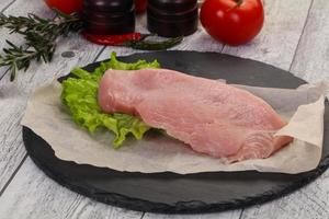 Raw Turkey steak served rosemary photo