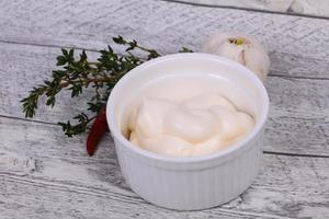 Mayonnaise sauce in the white bowl served thyme and garlic photo