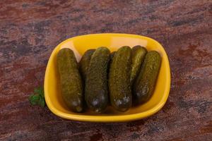 Pickled cucumbers heap in the bowl photo