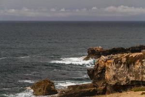 The waves fighting about deserted rocky coast of Atlantic ocean, Portugal photo