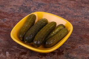 Pickled cucumbers heap in the bowl photo