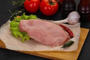 Raw Turkey steak served rosemary photo