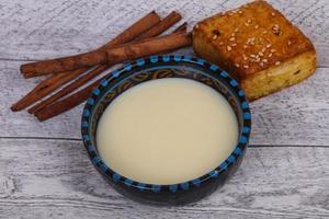 leche condensada en el bol con sinnamon y pastelería foto