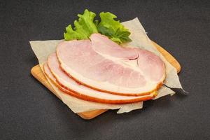 Sliced pork belly over board photo