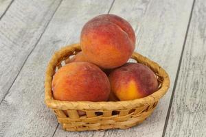 Peach heap in the wooden basket photo