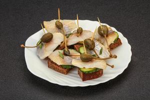 Herring fillet canape with caperberry photo