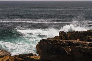 The waves fighting about deserted rocky coast of Atlantic ocean, Portugal photo