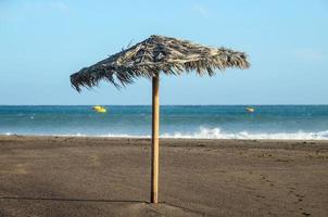 Straw umbrella on beach photo