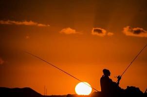 silueta de caña de pescar pescador foto