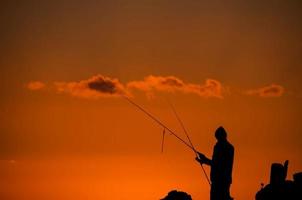 silueta de caña de pescar pescador foto