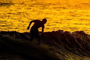 surfista de silueta al atardecer foto