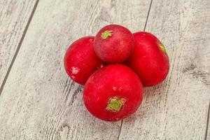 Ripe fresh radish heap over wooden photo