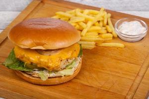 Homemade burger with fish, cheese and salad leaves photo