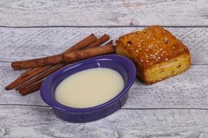 leche condensada en el bol con sinnamon y pastelería foto