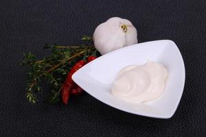 Mayonnaise sauce in the white bowl served thyme and garlic photo