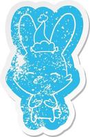 curious bunny cartoon distressed sticker of a wearing santa hat vector